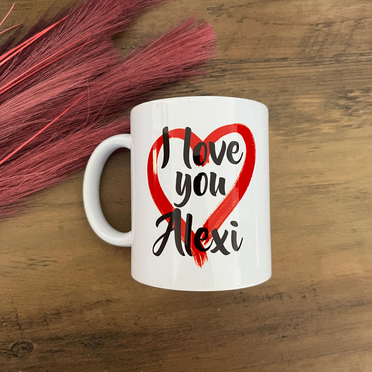 White mug with 'I love you Maxi' text on a wooden surface