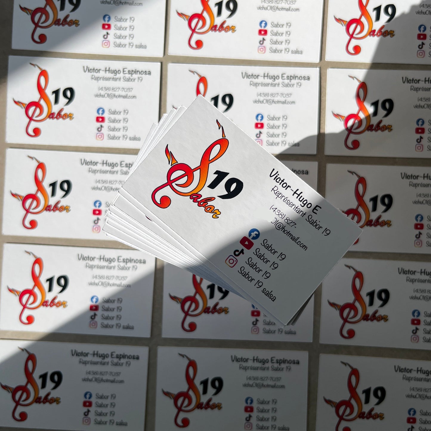 Stack of business cards with a logo and text on a textured surface