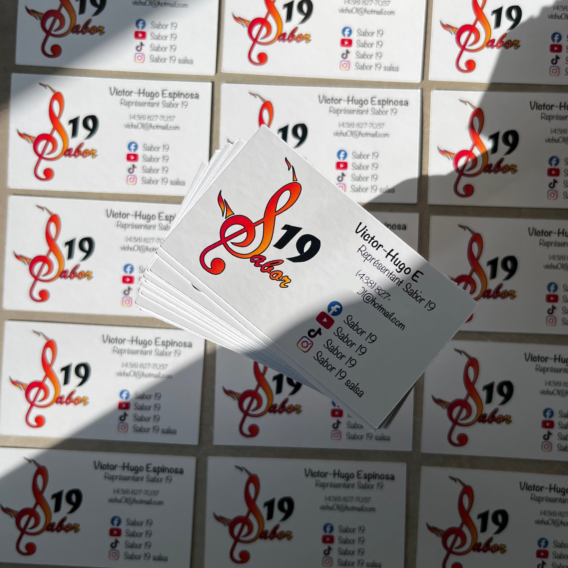 Stack of business cards with a logo and text on a textured surface