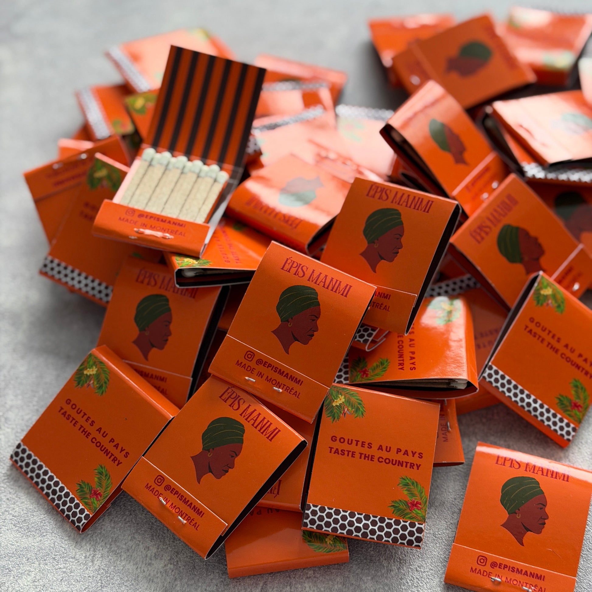Orange matchbooks with a face design on a gray surface
