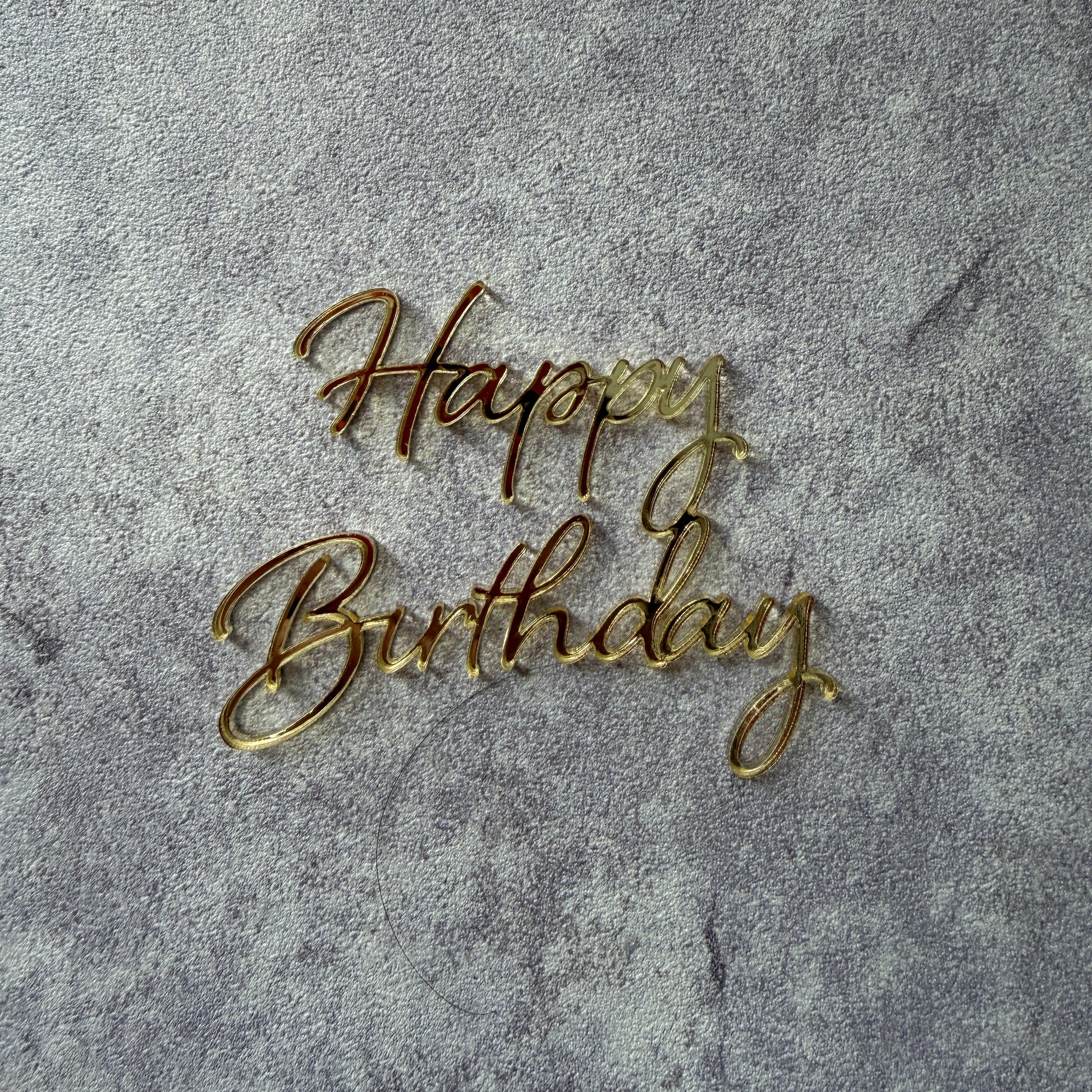 Gold 'Happy Birthday' text on a gray textured background