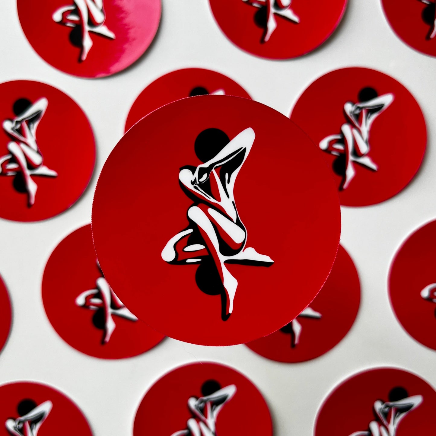 Red circular stickers with a white and black graphic of a person on a white background