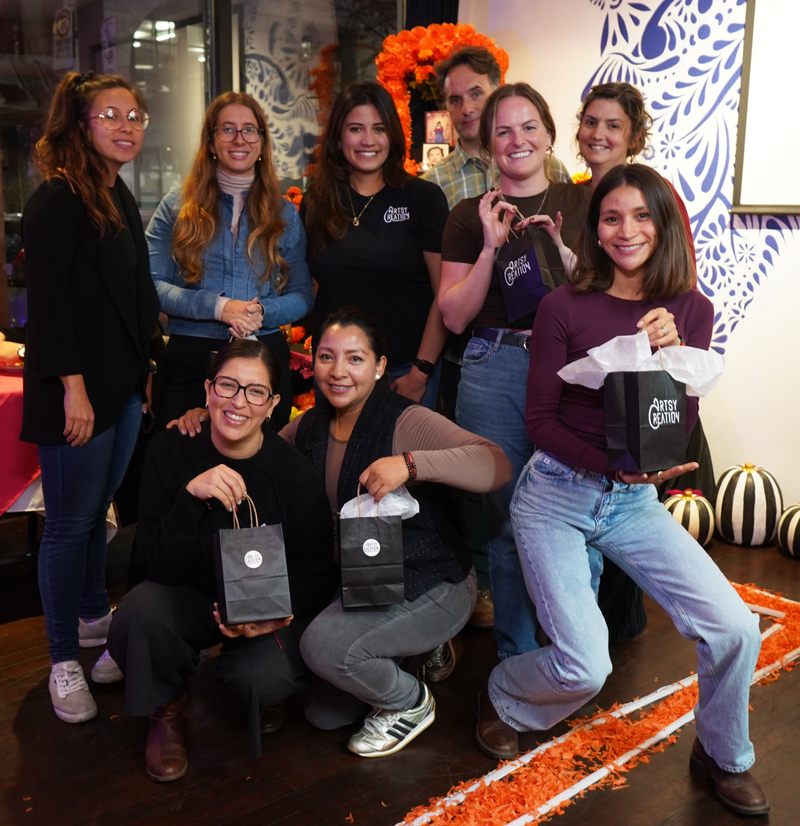 Group of people posing together with gift bags in a festive indoor setting.